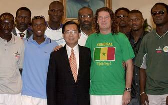 TPE02 - 20020624 - TAIPEI, TAIWAN : Taiwan President Chen Shui-bian stands beside with Senegal soccer team coach Bruno Metsu (R) as they pose with other team members at the presidential office in Taipei, 24 June 2002. Diplomatic isolated Taiwan invited Senegal, only the second African nation to reach a World Cup quarter-finals, to visit and play exhibition games as part of government efforts to cash in on the World Cup success of one of its few diplomatic allies.   EPA PHOTO POOL REUTERS
