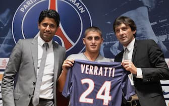 epa03309990 Italian midfielder Marco Verratti (C), newly signed player of French Ligue 1 soccer club Paris Saint-Germain, poses for photographers with Qatar Sports Investments (QSI) President Nasser Al-Khelaifi (L) and PSG manager Leonardo (R) during a press conference in Paris, France, 18 July 2012.  EPA/CHRISTOPHE KARABA