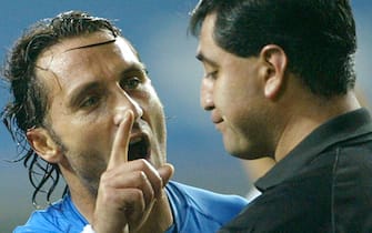 Italy's Angelo Di Livio (C) and Christian Vieri (L) protest as referee Byron Moreno (R) of Ecuador holds both yellow and red cards after he sent Italy's Francesco Totti off in extra time against South Korea during a second round World Cup Finals match in Taejon, June 18, 2002.
ANSA/DESMOND BOYLAN