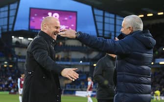 Burnley's English manager Sean Dyche (L) and Tottenham Hotspur's Portuguese head coach Jose Mourinho (R) embrace instead of shaking hands ahead of the English Premier League football match between Burnley and Tottenham at Turf Moor in Burnley, north west England on March 7, 2020. (Photo by Lindsey Parnaby / AFP) / RESTRICTED TO EDITORIAL USE. No use with unauthorized audio, video, data, fixture lists, club/league logos or 'live' services. Online in-match use limited to 120 images. An additional 40 images may be used in extra time. No video emulation. Social media in-match use limited to 120 images. An additional 40 images may be used in extra time. No use in betting publications, games or single club/league/player publications. /  (Photo by LINDSEY PARNABY/AFP via Getty Images)