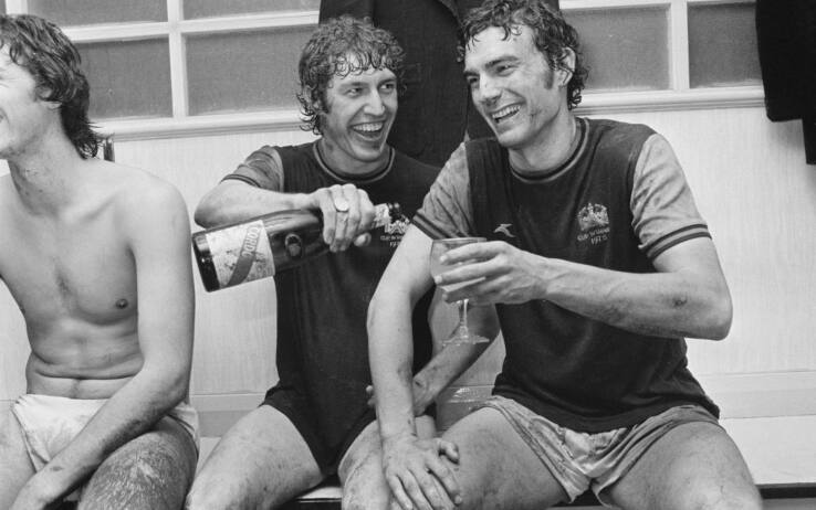 Trevor Brooking (a destra) festeggia con lo champagne l'approdo in finale di Coppa delle Coppe nel 1976