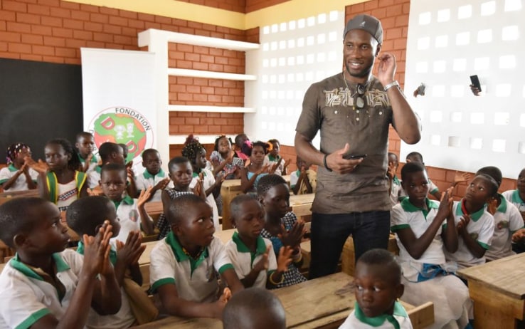 Didier posa coi bambini di una scuola in Costa d'Avorio inaugurata nel 2018 Didier posa coi bambini di una scuola in Costa d'Avorio inaugurata nel 2018