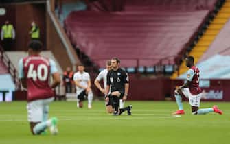 BIRMINGHAM, ENGLAND - JUNE 17: Both teams and match officials take a knee in support of the Black Lives Matter campaign during the Premier League match between Aston Villa and Sheffield United at Villa Park on June 17, 2020 in Birmingham, United Kingdom. (Photo by Matthew Ashton - AMA/Getty Images)
