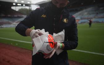 BIRMINGHAM, ENGLAND - JUNE 17: A member of ground staff disinfects the match ball after the players warm up prior to the Premier League match between Aston Villa and Sheffield United at Villa Park on June 17, 2020 in Birmingham, England. (Photo by Carl Recine/Pool via Getty Images)