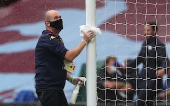 A staff member disinfects a goal post  prior to the  English Premier League football match between Aston Villa and Sheffield United at Villa Park in Birmingham, central England on June 17, 2020. - The Premier League makes its eagerly anticipated return today after 100 days in lockdown but behind closed doors due to coronavirus restrictions. (Photo by CARL RECINE / various sources / AFP) / RESTRICTED TO EDITORIAL USE. No use with unauthorized audio, video, data, fixture lists, club/league logos or 'live' services. Online in-match use limited to 120 images. An additional 40 images may be used in extra time. No video emulation. Social media in-match use limited to 120 images. An additional 40 images may be used in extra time. No use in betting publications, games or single club/league/player publications. /  (Photo by CARL RECINE/AFP via Getty Images)
