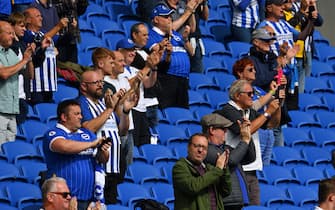 Supporters applaud the teams from their socially-distanced seats ahead of the pre-season friendly football match between Brighton and Hove Albion and Chelsea at the American Express Community Stadium in Brighton, southern England on August 29, 2020. - The game is a 'pilot' event where a small number of fans will be present on a socially-distanced basis. The aim is to get fans back into stadiums in the Premier League by October. (Photo by Glyn KIRK / AFP) (Photo by GLYN KIRK/AFP via Getty Images)