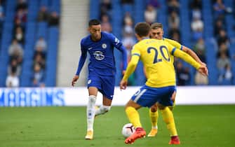 Chelsea's Moroccan midfielder Hakim Ziyech (L) vies with Brighton's English midfielder Solly March and Brighton's Belgian midfielder Leandro Trossard (R) as socially distanced fans watch from the stands during the pre-season friendly football match between Brighton and Hove Albion and Chelsea at the American Express Community Stadium in Brighton, southern England on August 29, 2020. - The game is a 'pilot' event where a small number of fans will be present on a socially-distanced basis. The aim is to get fans back into stadiums in the Premier League by October. (Photo by Glyn KIRK / AFP) (Photo by GLYN KIRK/AFP via Getty Images)