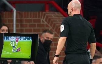 Referee Anthony Taylor consults VAR after a tackle during the Premier League match at Old Trafford, Manchester. Picture date: Sunday October 24, 2021.