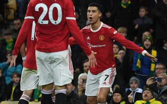 Manchester United's Portuguese striker Cristiano Ronaldo celebrates with teammates after scoring the opening goal from the penalty spot during the English Premier League football match between Norwich City and Manchester United at Carrow Road Stadium in Norwich, eastern England, on December 11, 2021. - RESTRICTED TO EDITORIAL USE. No use with unauthorized audio, video, data, fixture lists, club/league logos or 'live' services. Online in-match use limited to 120 images. An additional 40 images may be used in extra time. No video emulation. Social media in-match use limited to 120 images. An additional 40 images may be used in extra time. No use in betting publications, games or single club/league/player publications. (Photo by Daniel LEAL / AFP) / RESTRICTED TO EDITORIAL USE. No use with unauthorized audio, video, data, fixture lists, club/league logos or 'live' services. Online in-match use limited to 120 images. An additional 40 images may be used in extra time. No video emulation. Social media in-match use limited to 120 images. An additional 40 images may be used in extra time. No use in betting publications, games or single club/league/player publications. / RESTRICTED TO EDITORIAL USE. No use with unauthorized audio, video, data, fixture lists, club/league logos or 'live' services. Online in-match use limited to 120 images. An additional 40 images may be used in extra time. No video emulation. Social media in-match use limited to 120 images. An additional 40 images may be used in extra time. No use in betting publications, games or single club/league/player publications. (Photo by DANIEL LEAL/AFP via Getty Images)