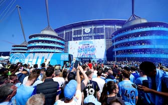 Manchester City fans celebrate as the team bus arrives ahead of the Premier League match at the Etihad Stadium, Manchester. Picture date: Sunday May 21, 2023.