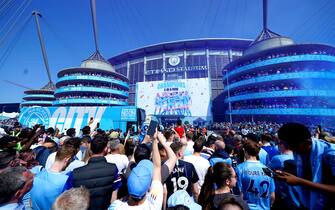 Manchester City fans celebrate as the team bus arrives ahead of the Premier League match at the Etihad Stadium, Manchester. Picture date: Sunday May 21, 2023.