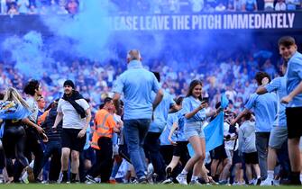 MANCHESTER, ENGLAND - MAY 21: A general view as fans of Manchester City invade the pitch, as the LED Perimeter Board displays the message "Please Leave The Pitch Immediately", after the final whistle of the Premier League match between Manchester City and Chelsea FC at Etihad Stadium on May 21, 2023 in Manchester, England. (Photo by Michael Regan/Getty Images)