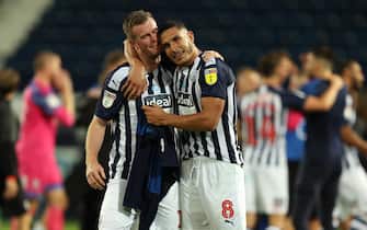 WEST BROMWICH, ENGLAND - JULY 22: Chris Brunt of West Bromwich Albion and Jake Livermore of West Bromwich Albion celebrate promotion  during the Sky Bet Championship match between West Bromwich Albion and Queens Park Rangers at The Hawthorns on July 22, 2020 in West Bromwich, England. Football Stadiums around Europe remain empty due to the Coronavirus Pandemic as Government social distancing laws prohibit fans inside venues resulting in all fixtures being played behind closed doors. (Photo by Matthew Ashton - AMA/Getty Images)