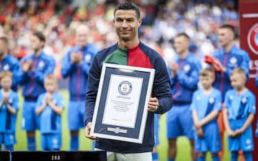 epa10702377 Portugal´s Cristiano Ronaldo receives a plaque from the Guiness Book of World Records for his 200th international appearance for the Portuguese national soccer team before the UEFA Euro 2024 qualifying soccer match between Iceland and Portugal, at Laugardalsvollur Stadium, in Reykjavik, Iceland, 20 June 2023.  EPA/JOSE SENA GOULAO
