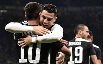 Juventus' Portuguese forward Cristiano Ronaldo (C) embraces Juventus' Argentine forward Paulo Dybala after Dybala opened the scoring during the Italian Serie A football match Inter vs Juventus on October 6, 2019 at the San Siro stadium in Milan. (Photo by Marco BERTORELLO / AFP) (Photo by MARCO BERTORELLO/AFP via Getty Images)