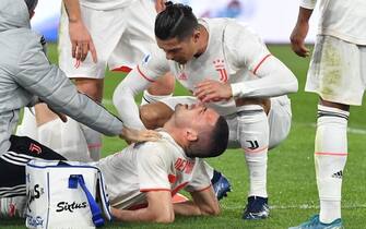 Juventus' Portuguese forward Cristiano Ronaldo (C) tend to Juventus' Turkish defender Merih Demiral after he was injured during the Italian Serie A football match AS Roma vs Juventus on January 12, 2020 at the Olympic stadium in Rome. (Photo by Tiziana FABI / AFP) (Photo by TIZIANA FABI/AFP via Getty Images)