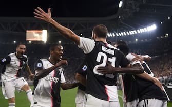 Juventus' Argentinian forward Gonzalo Higuain (C) celebrates with Juventus' Brazilian forward Douglas Costa (2ndL) after scoring a goal during the Italian Serie A football match Juventus vs Napoli on August 31, 2019 at the Juventus stadium in Turin. (Photo by Marco BERTORELLO / AFP)        (Photo credit should read MARCO BERTORELLO/AFP via Getty Images)