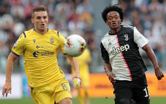 1170047286 TURIN, ITALY - SEPTEMBER 21: Juan Cuadrado (R) of Juventus runs after the ball during the Serie A match between Juventus and Hellas Verona at Allianz Stadium on September 21, 2019 in Turin, Italy. (Photo by Emilio Andreoli/Getty Images)