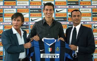 Milan, ITALY:  Swedish forward Zlatan Ibrahimovic (C) flanked by Gabriele Oriali (L) and Marco Branca poses with the Inter Milan's jersey in Appiano Gentile, northern Italy, 10 August 2006. Ibrahimovic has signed a four-year deal with Inter Milan after a 24.8 million euro (31.9 million dollar) agreement was reached by the club with Italian rivals Juventus. AFP PHOTO / GIUSEPPE CACACE  (Photo credit should read GIUSEPPE CACACE/AFP via Getty Images)