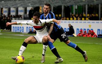 MILAN, ITALY - DECEMBER 21: Cristiano Biraghi of FC Internazionale competes for the ball with Francesco Cassata of Genoa CFC during the Serie A match between FC Internazionale and Genoa CFC at Stadio Giuseppe Meazza on December 21, 2019 in Milan, Italy. (Photo by MB Media/Getty Images)