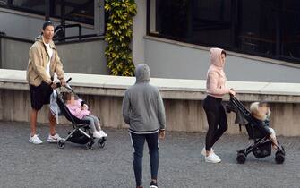 1208492144 Cristiano Ronaldo (L) and his partner Georgina Rodriguez push two strollers as they have a walk with their children in Funchal on March 28, 2020. (Photo by HELDER SANTOS / AFP) (Photo by HELDER SANTOS/AFP via Getty Images)
