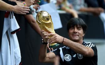 454471274 Germany's head coach Joachim Loew shows the world cup trophy during a public training session of the German national football team in Duesseldorf, Germany on September 1, 2014. Germany's squad prepares for the upcoming friendly game against Argentina on September 3, 2014 in Duesseldorf. AFP PHOTO / PATRIK STOLLARZ (Photo credit should read PATRIK STOLLARZ/AFP via Getty Images)