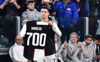 Juventus' Portuguese forward Cristiano Ronaldo holds a jersey bearing his name with the numver 700, after being honoured for having scored 700 goals so far during his career, prior to the Italian Serie A football match Juventus vs Bologna on October 19, 2019 at the Juventus stadium in Turin. (Photo by Marco Bertorello / AFP) (Photo by MARCO BERTORELLO/AFP via Getty Images)