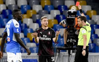 The referee Federico La Penna   shows the yellow card to     Milan's midfielder Alexis Saelemaekers   during  italian Serie A  soccer  match   SSC Napoli vs  AC Milan   at the San Paolo stadium in Naples, 12  july 2020. 
ANSA / CIRO FUSCO
