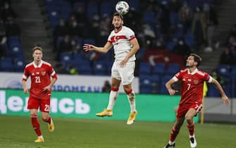 epa08736415 Anton Miranchuk (L) and Magomed Ozdoev (R) of Russia in action against Hakan Calhanoglu (C) of Turkey during the UEFA Nations League soccer match between Russia and Turkey at the VTB Arena in Moscow, Russia, 11 October 2020.  EPA/YURI KOCHETKOV