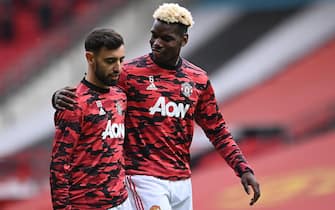 epa09209216 Manchester United’s Bruno Fernandes (L) is comforted by Manchester United’s Paul Pogba (R) as they warm-up for the English Premier League soccer match between Manchester United and Fulham FC in Manchester, Britain, 18 May 2021.  EPA/Laurence Griffiths / POOL EDITORIAL USE ONLY. No use with unauthorized audio, video, data, fixture lists, club/league logos or 'live' services. Online in-match use limited to 120 images, no video emulation. No use in betting, games or single club/league/player publications.