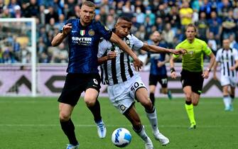 Inter Milan's Bosnian forward Edin Dzeko (L) is challenged by Udinese's Brazilian defender Rodrigo during the Serie A football match between Udinese and Inter Milan at Friuli stadium in Udine on May 1, 2022. (Photo by MIGUEL MEDINA / AFP) (Photo by MIGUEL MEDINA/AFP via Getty Images)