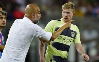 epa10137043 Manchester City's head coach Pep Guardiola (L) talks to his player Kevin De Bruyne during the friendly soccer match between FC Barcelona and Manchester City held at Camp Nou Stadium, in Barcelona, Spain, 24 August 2022.  EPA/ENRIC FONTCUBERTA