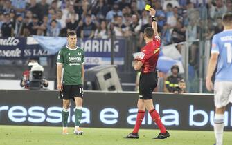 Referee Andrea Colombo shows the yellow card to Nicolo Casale of Hellas Verona FC during SS Lazio vs Hellas Verona FC, 38Â° Serie A Tim 2021-22 game at Olimpic stadium in Roma, Italy, on May 21, 2022.