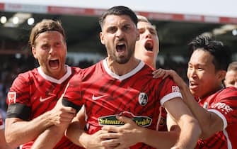 epa09423241 Freiburg’s Vincenzo Grifo (C) celebrates with teammates after scoring the opening goal during the German Bundesliga soccer match between SC Freiburg and Borussia Dortmund in Freiburg, Germany, 21 August 2021.  EPA/RONALD WITTEK CONDITIONS - ATTENTION: The DFL regulations prohibit any use of photographs as image sequences and/or quasi-video.
