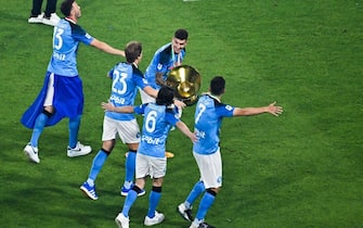 Napoli's Italian defender Giovanni Di Lorenzo (C) holds the Italian Scudetto Championship trophy as he and his teammates celebrate winning the 2023 Scudetto championship title on June 4, 2023, following the Italian Serie A football match between Napoli and Sampdoria at the Diego-Maradona stadium in Naples. (Photo by Tiziana FABI / AFP) (Photo by TIZIANA FABI/AFP via Getty Images)