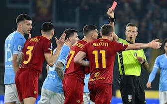 Italian referee Davide Massa (R) shows a red card to AS Roma's Roger Ibanez (2-L) during the Italian Serie A soccer match between SS Lazio and AS Roma at the Olimpico stadium in Rome, Italy, 19 March 2023.  ANSA/ETTORE FERRARI