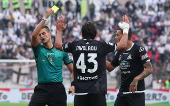 Referee Daniele Perenzoni  shows the yellow card to Spezia's defender Dimitrios Nikolaou during the Italian Serie A soccer match between AC Monza and Spezia at U-Power Stadium in Monza, Italy, 9 October 2022. ANSA / ROBERTO BREGANI