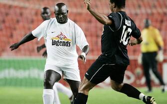 Johannesburg, SOUTH AFRICA:  Liberian international football star and Former Liberian Presidential election candidate George Weah (L) passes European football legend Ruud Gullit (R) from the Netherlands during the match between African and European soccer legends at Ellis Park stadium in Johannesburg 07 January 2005. Weah pledged his support to his successful rival in the presidential run-off in Liberia. The presidential poll, which ended a transition period after two brutal successive civil wars, was won on November 8 by Johnson Sirleaf, 67, a former World Bank economist and veteran politician.   AFP PHOTO/GIANLUIGI GUERCIA  (Photo credit should read GIANLUIGI GUERCIA/AFP via Getty Images)