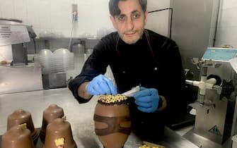 Il maestro cioccolataio Umberto Pignatiello mostra le uova pasquali da lui realizzate con le sembianze dell'attaccante del Napoli Victor Osimhen, 02 marzo 2023.      ANSA