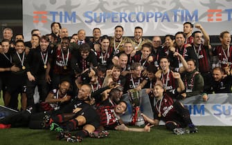 AC Milan's players pose with the trophy after winning against Juventus during the Italian Super Cup final match between AC Milan and Juventus in Doha on December 23, 2016.AC Milan beat Juventus to win the Italian Super Cup in a penalty shootout, the first trophy the Rossoneri have won since 2011. / AFP / KARIM JAAFAR        (Photo credit should read KARIM JAAFAR/AFP via Getty Images)