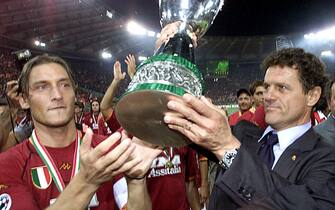 Il capitano della Roma. Francesco Totti, e l'allenatore giallorosso Fabio Capello stringono la Supercoppa dopo la partita contro la Fiorentina, il 20 agosto 2001.
ANSA/ALESSANDRO BIANCHI