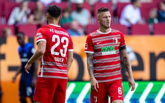 04 September 2022, Bavaria, Augsburg: Soccer: Bundesliga, FC Augsburg - Hertha BSC, Matchday 5, WWK Arena. Augsburg's Maximilian Bauer (l) and Augsburg's Jeffrey Gouweleeuw (r) react during the match. Photo: Tom Weller/dpa - IMPORTANT NOTE: In accordance with the requirements of the DFL Deutsche Fußball Liga and the DFB Deutscher Fußball-Bund, it is prohibited to use or have used photographs taken in the stadium and/or of the match in the form of sequence pictures and/or video-like photo series.