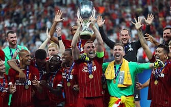 epa07773924 Liverpool's Jordan Henderson (C) lifts the trophy as his teammates celebrate after winning the UEFA Super Cup soccer match between Liverpool FC and Chelsea FC in Istanbul, Turkey, 14 August 2019.  EPA/SEDAT SUNA