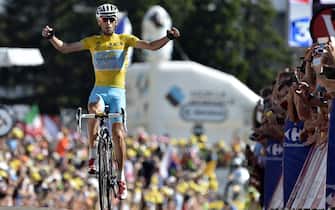 452336418 Italy's Vincenzo Nibali wearing the overall leader's yellow jersey celebrates as he crosses the finish line at the end of the 197.5 km thirteenth stage of the 101st edition of the Tour de France cycling race on July 18, 2014 between Saint-Etienne and Chamrousse, central eastern France. AFP PHOTO / JEFF PACHOUD (Photo credit should read JEFF PACHOUD/AFP via Getty Images)