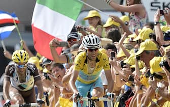 452382774 France's Jean-Christophe Peraud (L) and Italy's Vincenzo Nibali wearing the overall leader's yellow jersey sprint to cross the finish line, riding past an Italian national flag at the end of the 177 km fourteenth stage of the 101st edition of the Tour de France cycling race on July 19, 2014 between Grenoble and Risoul, eastern France. Poland's Rafal Majka won the stage. AFP PHOTO / JEFF PACHOUD (Photo credit should read JEFF PACHOUD/AFP via Getty Images)
