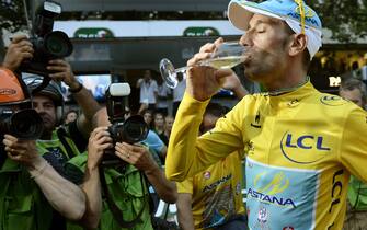 452798170 Tour de France 2014's winner Italy's Vincenzo Nibali drinks champagne on the Champs-Elysees avenue in Paris, at the end of the 137.5 km twenty-first and last stage of the 101st edition of the Tour de France cycling race on July 27, 2014 between Evry and Paris. AFP PHOTO / JEFF PACHOUD (Photo credit should read JEFF PACHOUD/AFP via Getty Images)