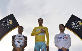 Tour de France 2014's winner Italy's Vincenzo Nibali (C), second-placed France's Jean-Christophe Peraud (L) and third-placed France's Thibaut Pinot (R) stand on the podium on the Champs-Elysees avenue in Paris, at the end of the 137.5 km twenty-first and last stage of the 101st edition of the Tour de France cycling race on July 27, 2014 between Evry and Paris. AFP PHOTO / JEFF PACHOUD (Photo credit should read JEFF PACHOUD/AFP via Getty Images)