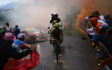 TOPSHOT - Great Britain's Simon Yates leads the race as as orange smoke billows in the last kilometers during the fifteen stage of the 106th edition of the Tour de France cycling race between Limoux and Foix Prat d'Albis, in Foix Prat d'Albis on July 21, 2019. (Photo by Anne-Christine POUJOULAT / AFP)        (Photo credit should read ANNE-CHRISTINE POUJOULAT/AFP via Getty Images)