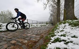 Illustration picture shows snow as a cyclist rides up the Koppenberg during a training session on the track of the Ronde van Vlaanderen cycling race, Friday 01 April 2022. The 106th edition of the cycling race will take place on Easter Sunday 03 April. BELGA PHOTO DIRK WAEM (Photo by DIRK WAEM / BELGA MAG / Belga via AFP) (Photo by DIRK WAEM/BELGA MAG/AFP via Getty Images)