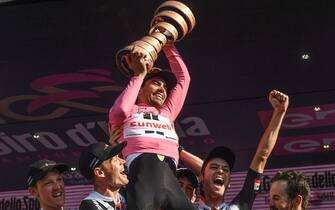 Dutch rider Tom Dumoulin holds up the trophy celebrating on the podium with his teammates of Sunweb after winning the 100th Giro d'Italia 2017 cycling race at the end of the 21st and last stage, a 29,3 km trial from Monza to Milan, Italy, 28 May 2017. 
ANSA/ALESSANDRO DI MEO

